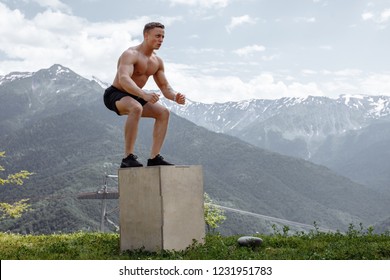 Sportsman trainer at outdoor street crossfit workout performing explosive strength training jumps outdoor, in modern fitness park in mountains area. Bodybuilding and outdoor sports concept - Powered by Shutterstock