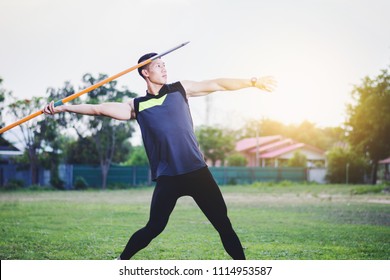 sportsman warming up and practicing javelin throw in yard - Powered by Shutterstock