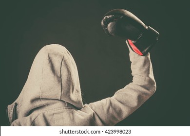 Sportsmanship and strong body. Win fight with opponent. Young woman wear hoodie victory pose show emotion with arm in air. Girl wear boxing gloves.