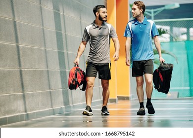 Sportsmen discussing news when walking in corridor of health club with gym bags - Powered by Shutterstock