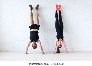 sportsmen woman and man doing a handstand against wall concept balance sport fitness lifestyle and people.