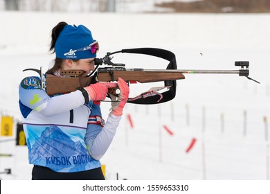 Sportswoman biathlete Elena Hairulina (Yugorsk) rifle shooting in standing position. Biathlete in shooting area of Open regional youth biathlon competitions East Cup. Kamchatka, Russia - Apr 12, 2019