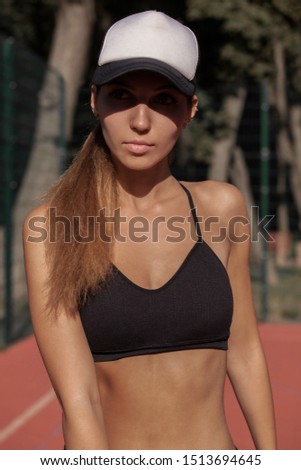Sportswoman in a cap on a tennis court