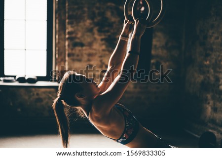 Similar – young adult trained woman concentrate at her excercise in gym