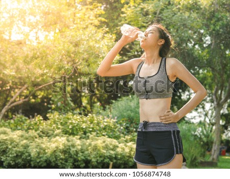 Sportswoman drinking water from a bottle.