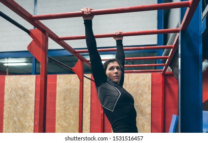 Sportswoman exercising on monkey bars at the gym - Powered by Shutterstock