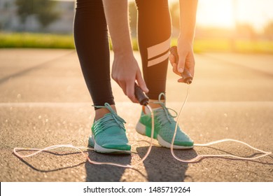 Sportswoman is preparing to do cardio exercises with skipping rope outdoors  - Powered by Shutterstock