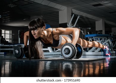 Sportswoman. Slim girl training in a gym