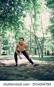 A Sportswoman Stretching Legs And Doing Warmup Exercises In The Nature.