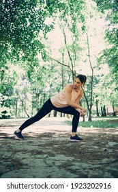 A Sportswoman Stretching Legs And Doing Warmup Exercises In The Nature.