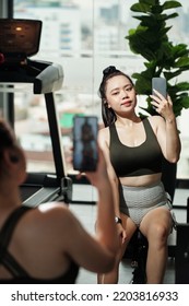 Sportswoman Taking Selfie In Front Of Gym Mirror