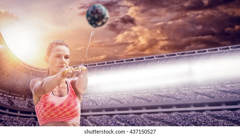 Sportswoman throwing a hammer against composite image of stadium - Powered by Shutterstock