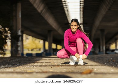 A sportswoman is tying shoelace outdoors. - Powered by Shutterstock