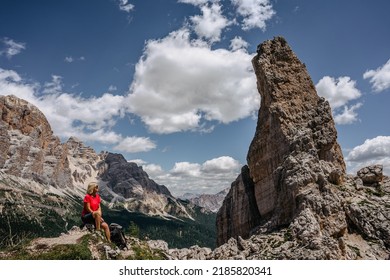 Sporty active woman climbing in Cinque Torri,Dolomites,Italy.Five towers and rock formations close to Cortina d'Ampezzo attract many climbers.Happy female with backpack in picturesque Dolomite Alps