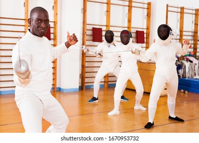 Sporty african american man fencer practicing effective fencing techniques in a training room  - Powered by Shutterstock