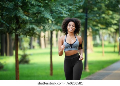 Sporty African American Woman Running In Park