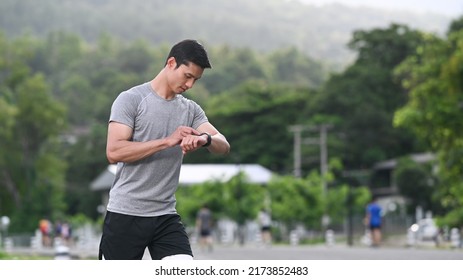 Sporty Asian Man Resting And Checking His Heart Rate Data On Smartwatch During Morning Workout