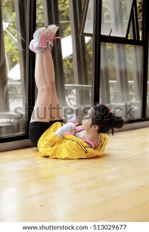 Sporty asian woman doing stretching hamstring while lying on floor