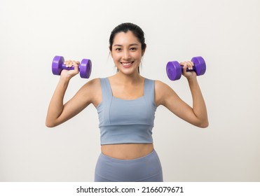 Sporty Asian woman exercises with dumbbells on isolated white background. Good shape and health fitness woman weight training standing pose smile to camera.