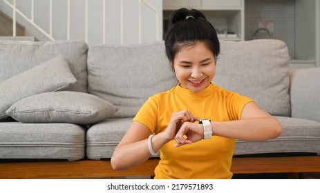 Sporty Asian Woman Resting And Checking Heart Rate Data On Smartwatch During Exercising At Home