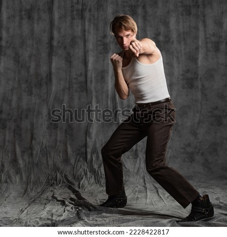 Similar – Image, Stock Photo Close up front portrait of one young middle age athletic woman in sportswear in gym over dark background, standing in boxing stance with hands and fists, looking at camera