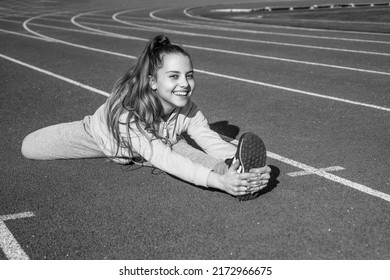 Sporty Beauty. Confident Flexible Athlete. Teen Girl Warming Up On Stadium. Kid In Sportswear Stretching. Child Do Split Exercise On Racing Track. Healthy Childhood. Workout On Fresh Air Outdoor