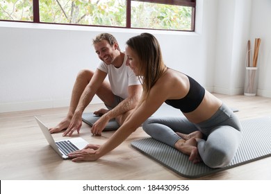 sporty couple in sportswear doing exercise using laptop at home