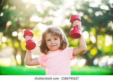 Sporty Cute Blonde Boy With Dumbbells Outdoor. Fitness Kids, Health And Energy. Healthy Kids Lifestyle. Kid Exercising With Dumbbell. Sport For Little Children.