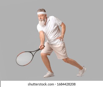 Sporty Elderly Tennis Player On Grey Background