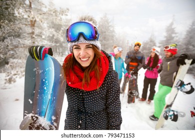 Sporty Female Holds Snowboard In Mountains On Winter Holiday