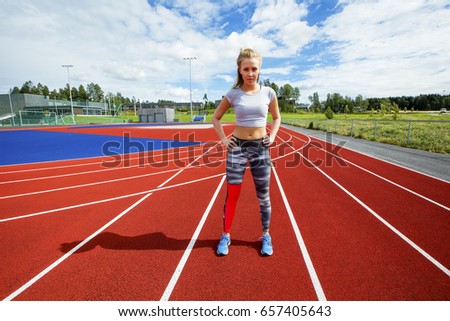 Sporty Female Standing With Hands On Hips On Running Tracks