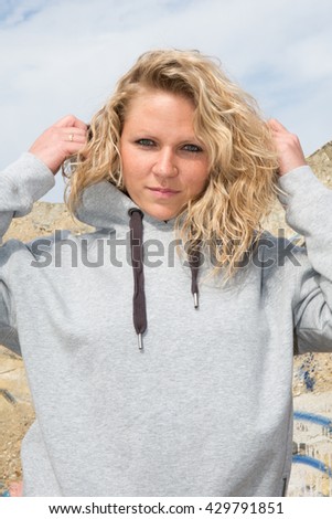 Sporty fit blond woman in grey sportswear working out outdoors on summer day,