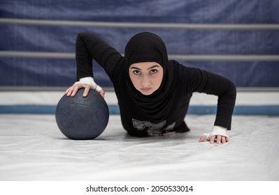 Sporty Fit Muslim Woman In Hijab Exercise Push-ups On Medical Ball. Female Boxer Exercise. Selective Focus