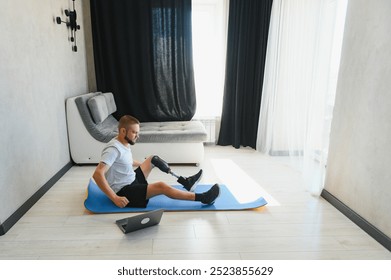 Sporty fit young man amputee with prosthetic leg disability prosthesis doing plank exercise on mat at home. Inclusive sport training for people with disabilities concept. Close up shot - Powered by Shutterstock