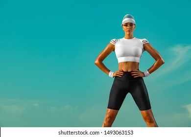 Sporty and fit young woman athlete relaxed after yoga training on the sky background. The concept of a healthy lifestyle and sport. Individual sports recreation.