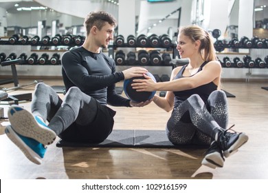 Sporty Fitness Couple Doing Abdominal Exercises With Medicine Ball In The Gym.