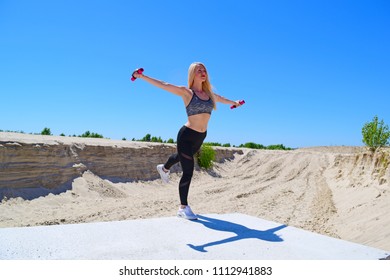 Sporty Girl Doing Swallow Exercise On Concrete Near The Desert
