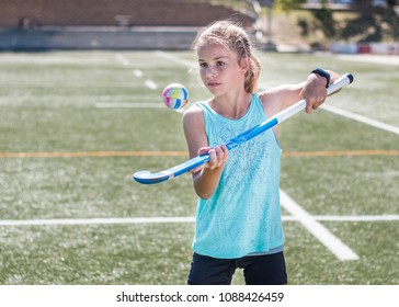 Sporty girl hopping a hockey ball on her hockey stick. - Powered by Shutterstock