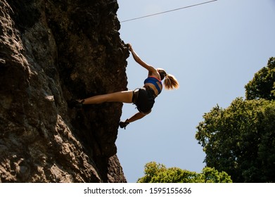 Sporty Girl With Ponytail Climbs On The Sheer Rock Wall