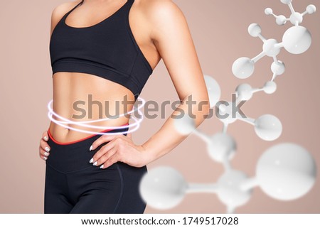 Sporty girl with slim belly posing among DNA stems. Good metabolism concept. Over beige background.