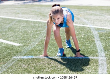 Sporty Girl Standing On Her Marks Ready To Run, Looking Focused And Ready On Running Sports Track.