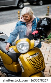 Sporty Grandmother Is Preparing For Riding Motorbike With Helmet