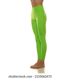 Sporty green leggings on slim pretty bare legs on a white background. Side view.
