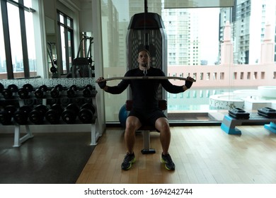 Sporty Guy Training In Gym On Pull Up Machine