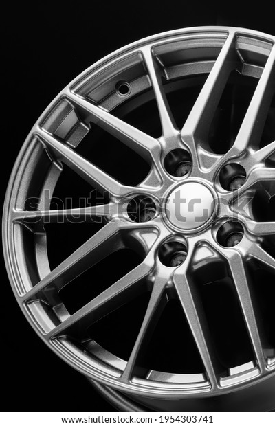 sporty lightweight\
alloy wheel, spokes and rim close-up on a black background, close\
up vertical photo
