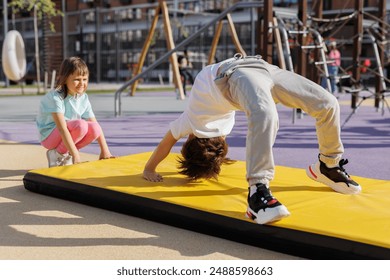 Sporty little boy does gymnastic exercises on a modern playground - Powered by Shutterstock