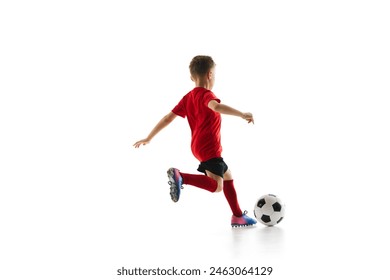 Sporty little boy, kicks ball to make perfect shot in motion against white studio background. Small football player makes perfect pass. Concept of professional sport, championship, youth league, hobby - Powered by Shutterstock