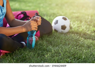 Sporty little girl with bottle of water sitting on grass - Powered by Shutterstock