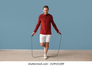 Sporty Man Jumping Rope On Color Background