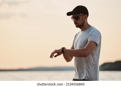 Sporty Man Looking At His Smart Fitness Watch .